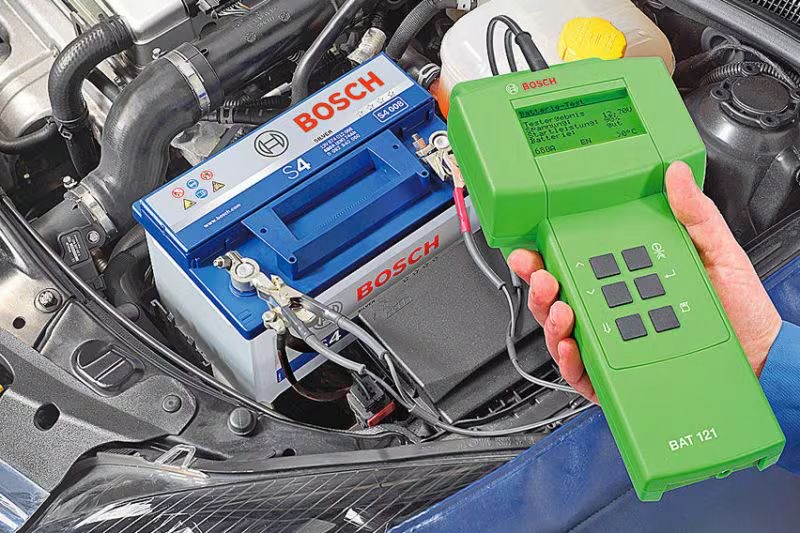 Bosch auto-accu en professionele accutester onder de motorkap van een auto